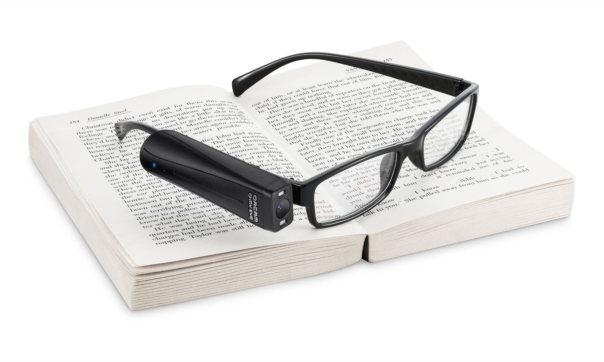 OrCam MyEye 2.0 colocado en la patilla de unas gafas, sobre un libro abierto